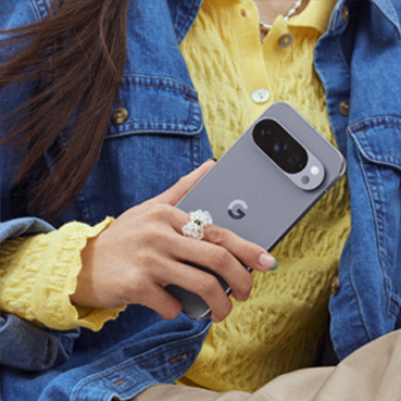 A close-up shot shows a person's hands holding a Pixel 10 Pro. in Moonstone
