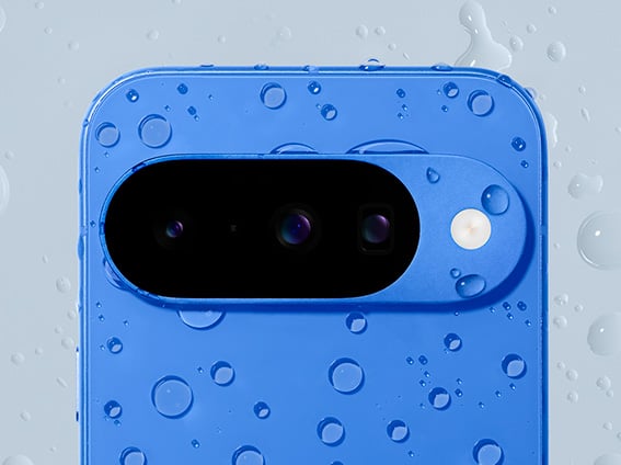 Image shows a Pixel 10 in indigo covered in warter drops 
